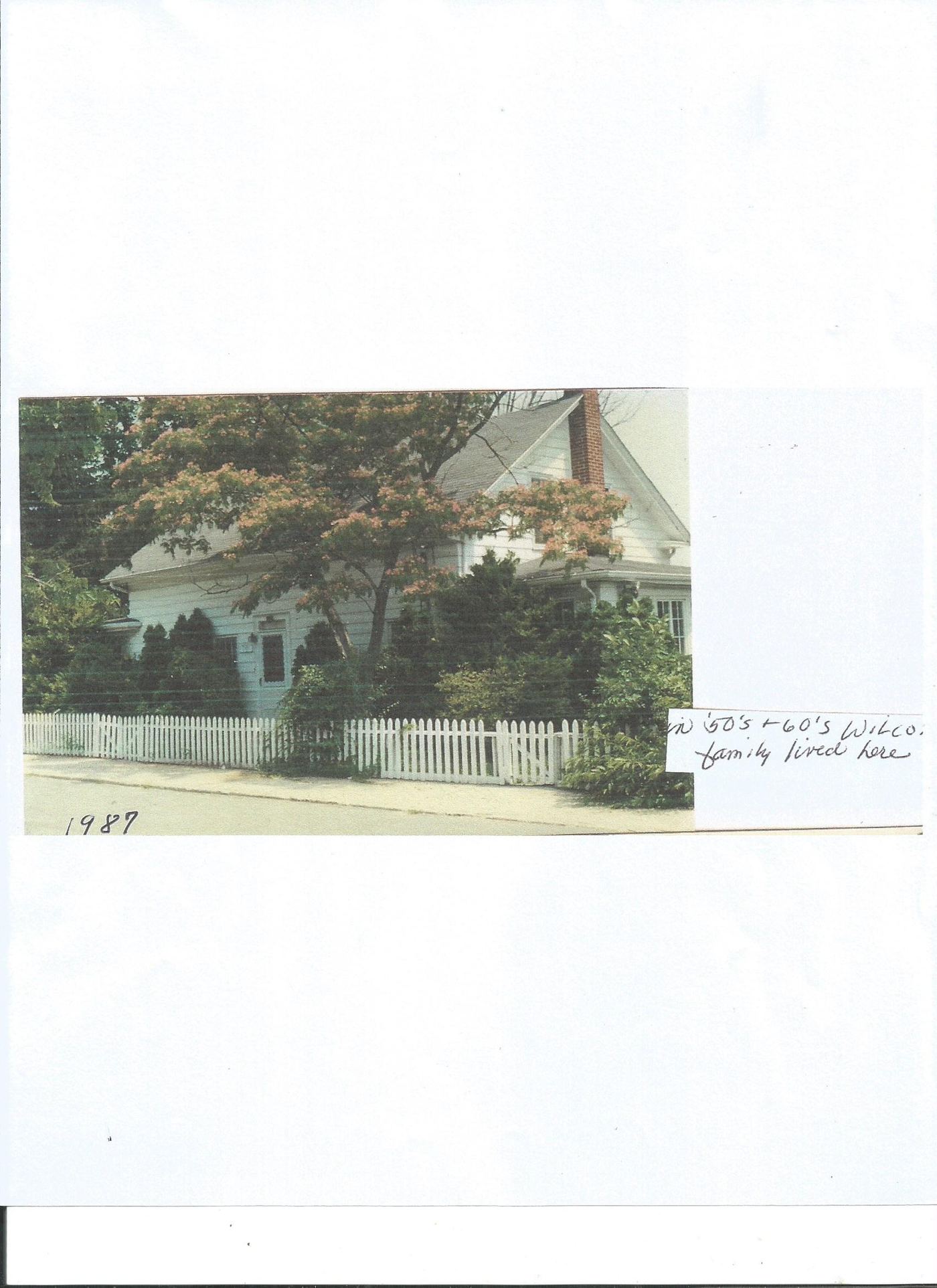 1987 photograph of the Wilcox family home behind a white picket fence
