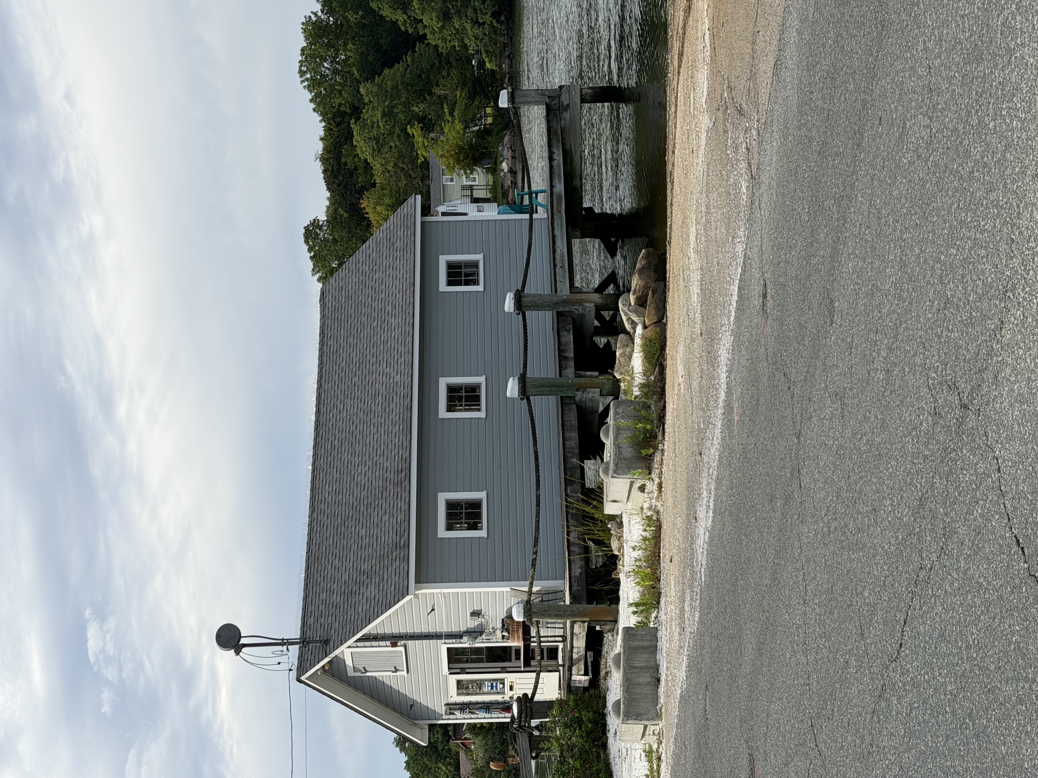 A dark blue shanty-type building beside the railway trestle at Apponaug Cove, seen from the parking area